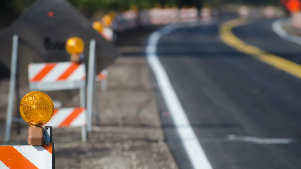 Traffic cones and warning signs creating a protected highway work zone.