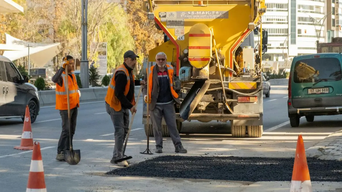 Professional road-construction crew wearing high-visibility safety equipment.